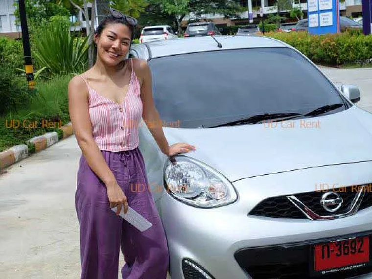 Illustrative smiling traveler with car keys giving a thumbs-up beside a family car